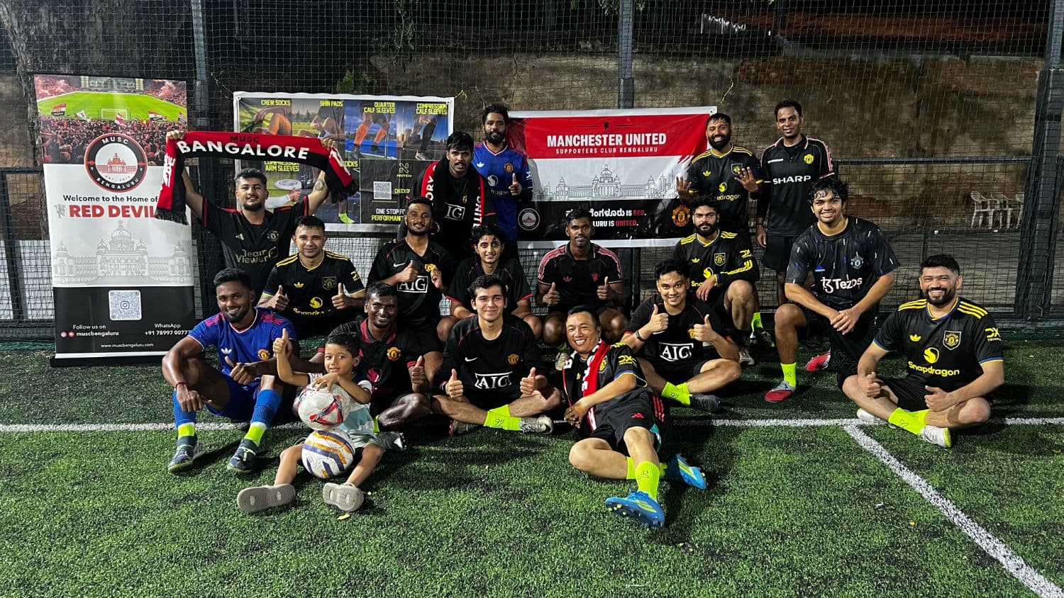 MUSCB players and a young supporter gathered in front of the club banners after a five-a-side session in Bengaluru.